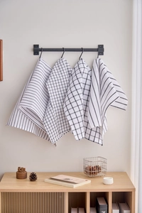 Detail of four Nordic style black and white plaid and striped cotton tea towels hanging