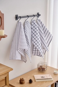 Detail of checkered and striped cotton kitchen towels hanging on a black metal rack