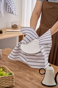 Detail of a striped cotton dish cloth used for holding a ceramic plate in a kitchen setting