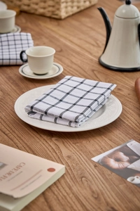 Close-up of minimalist black and white checkered cotton linen napkin on a wooden table