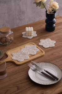 Detailed macro view of handmade star-shaped beige cotton woven coasters in a five-piece set