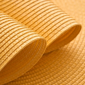 Minimalist round woven PP heat resistant placemat in bright ginger yellow color