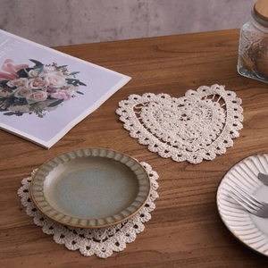 Handmade crochet cotton coasters set in heart and round shapes on wooden table