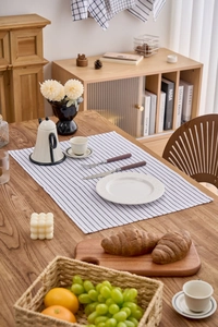 Detailed shot of a Nordic striped cotton linen placemat on a rustic wooden table setup