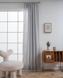 Detail of checkered curtain with cream tassels and rustic cotton linen texture