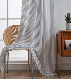 Detailed texture of beige vertical striped curtain fabric with elegant fringe tassel trim