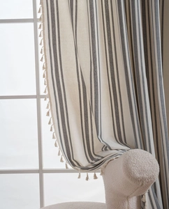 Detail of French striped linen curtain featuring beige tassels and gray vertical stripes