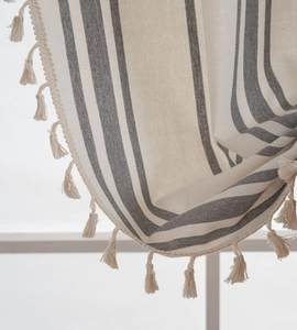 Close-up of striped cotton linen fabric featuring elegant tassels for home decor