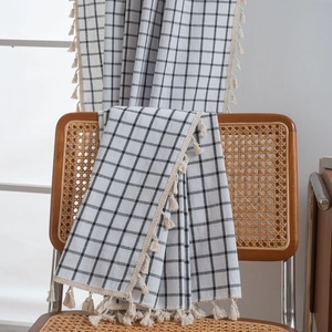 French style black and white checkered window curtain with decorative beige tassels on chair