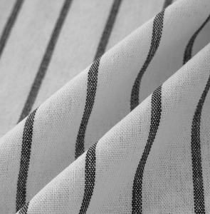 Close-up of black and white striped curtain fabric showing woven texture and soft drape