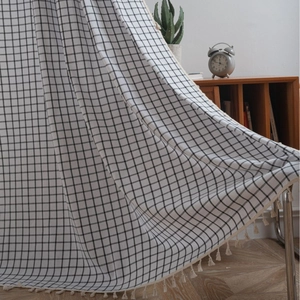 Classic black and white checkered curtain with elegant beige tassel fringe detailing