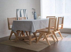 Close-up of gray grid pattern linen tablecloth on a wooden table in natural light