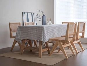 Close-up of black and white checkered linen tablecloth on a minimalist wooden dining table