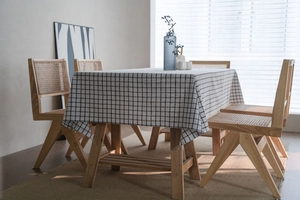Detailed close-up of a rustic checkered cotton linen tablecloth with natural drape and texture