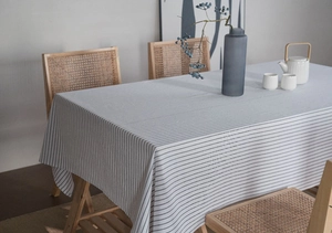 Detail shot of minimalist cream linen tablecloth with classic black stripe patterns