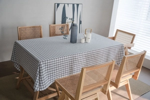 Detail of classic black and white checkered linen tablecloth on a wooden dining table