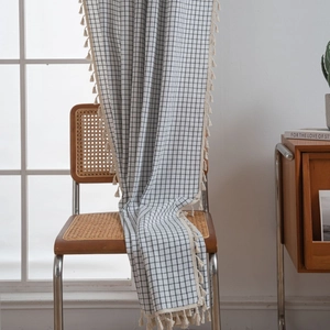 Modern black and white checkered window curtain with decorative cream fringe tassels