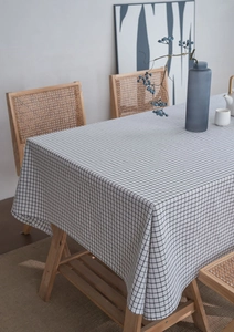 Detailed view of black and white plaid linen tablecloth draped on a wooden table