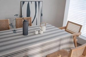 Close-up of minimalist grey striped tablecloth with cotton linen texture and soft drape
