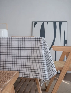 Detail of minimalist black and white checkered linen tablecloth on a wooden table