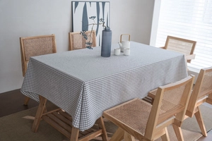 Close-up of black and white checkered linen tablecloth on a rectangular wooden table