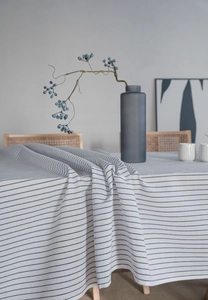 Macro detail of breathable cotton linen striped tablecloth with natural draped edges