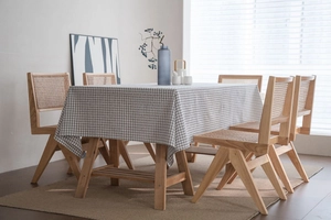 Detail of minimalist black and white checkered linen tablecloth on a wooden dining table
