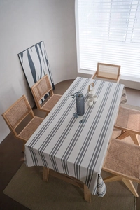 Detailed top view of striped linen rectangular tablecloth on dining table with rattan chairs