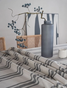 Detailed view of striped linen blend tablecloth with elegant waves and modern drape texture