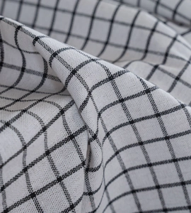 Close-up detail of black and white checkered cotton linen fabric with woven texture