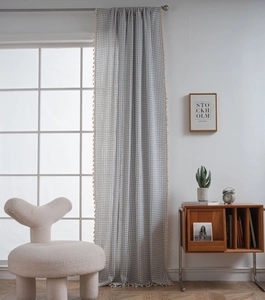 Close-up of black and white checkered curtain with dense decorative tassel trim