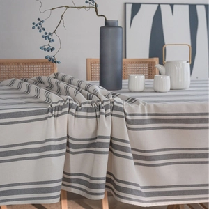 Modern minimalist table cloth with grey stripes and woven texture on a wooden table