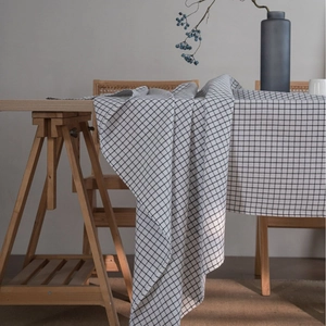 Minimalist black and white checkered linen tablecloth displayed on a wooden table