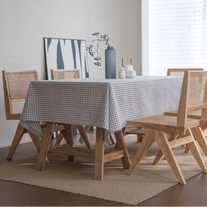 Black and white gingham linen tablecloth on a wooden table in a minimalist dining room