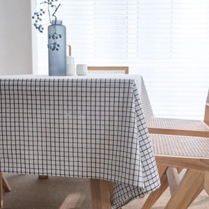 Classic black and white checkered linen tablecloth on a wooden table for home dining