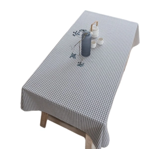 Minimalist black and white plaid linen tablecloth draped over a wooden dining table