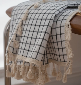 Macro detail of plaid fabric curtain with cotton linen texture and cream tassel edges