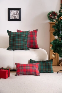 Detailed view of red and green festive plaid pillow covers set on a cozy sofa