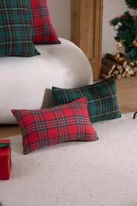 Macro view of red and green plaid festive cushion covers on a sofa in Christmas setting