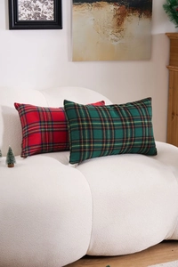 Close-up of red and green plaid festive cushion covers on a soft boucle sofa texture