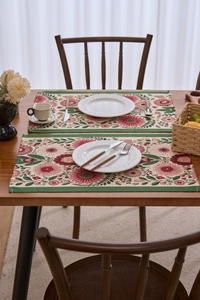 Nahaufnahme von Jacquard-Platzsets mit roten Blumen auf einem rustikalen Holztisch