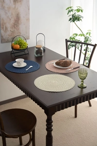 Detailed view of woven round placemats in navy blue, dusty pink, and cream white textures