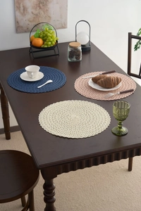 Detail of round woven placemats in blue and beige showing intricate hollow spiral patterns