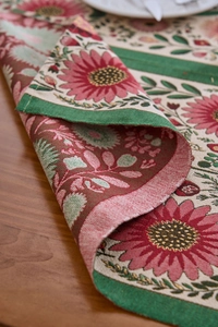 Detailansicht der gewebten roten floralen Platzset-Textur auf einem rustikalen Holztisch
