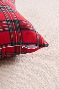 Close-up of red plaid pillow cover showing hidden zipper and textured woven fabric