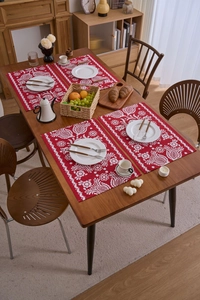 Detailansicht von vier roten festlichen Jacquard-Platzsets mit weißen Blumenmustern