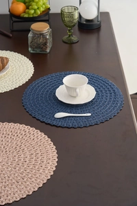 Detailed view of round woven heat-resistant placemats with scalloped edges in various colors