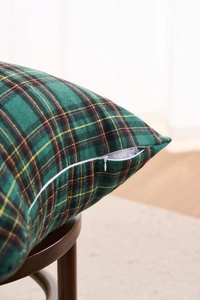 Macro detail of the invisible zipper on a green plaid festive cotton cushion cover