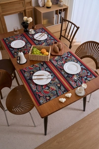 Nahaufnahme von vier Jacquard-Tischsets mit Blumenmuster und roter Umrandung