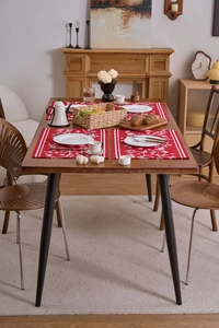 Detaillierte Ansicht roter Tischsets mit Blumenmuster und weißem Geschirr auf Holztisch